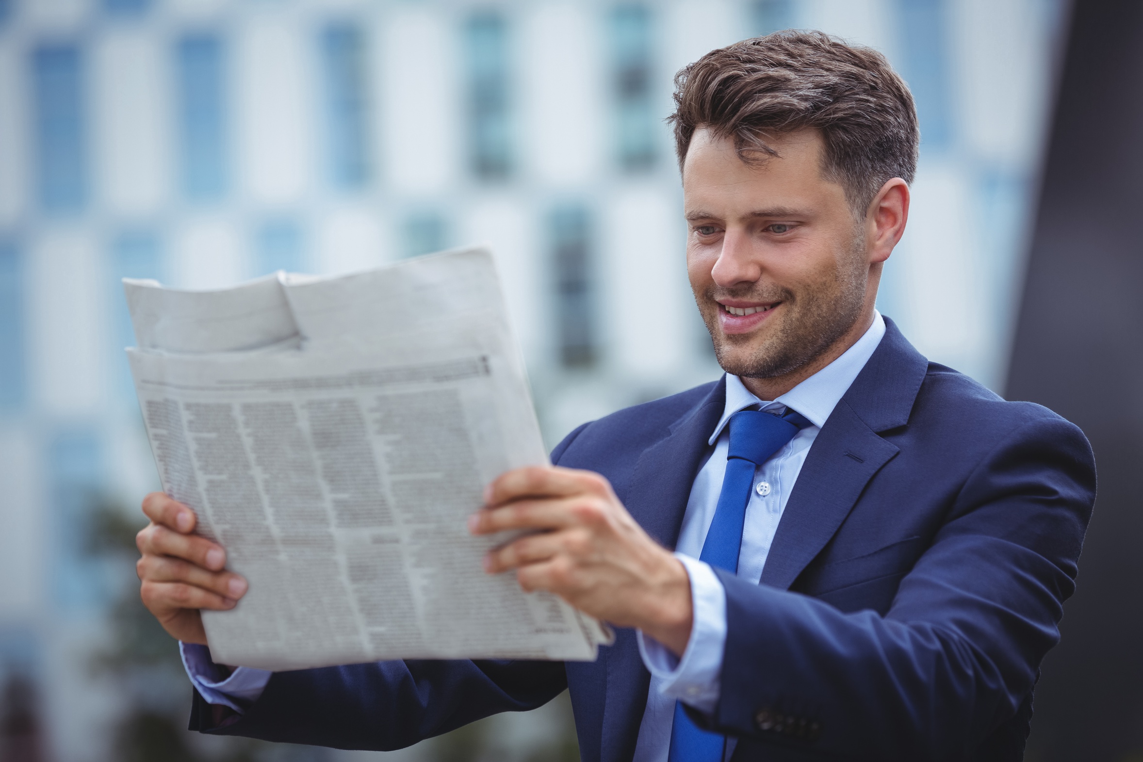 Handsome businessman reading newspaper